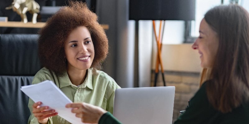 A woman confidently presenting her resume and displaying digital credentials earned during a job interview